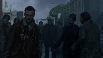 Movie still from “The Walking Dead” (2010), directed by Daniel Sackheim – A group of zombies walking down the street; Medium shot, Low angle