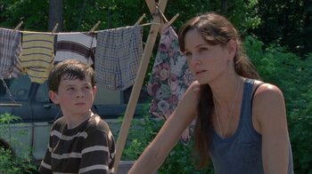 Movie still from “The Walking Dead” (2010), directed by Daniel Sackheim – A woman and a young boy standing in front of a clothesline; Medium shot, Low angle