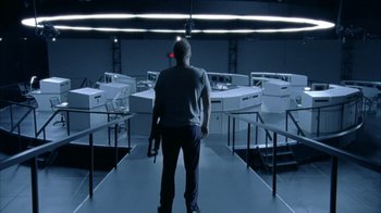 Movie still from “The Walking Dead” (2010), directed by Daniel Sackheim – A man standing in front of a bunch of computers in a room; Wide shot, Low angle