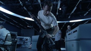 Movie still from “The Walking Dead” (2010), directed by Daniel Sackheim – A man holding an ar - 1 5 style rifle in a room; Medium shot, Low angle