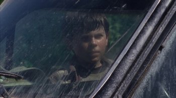 A young boy looking out of the window of a car