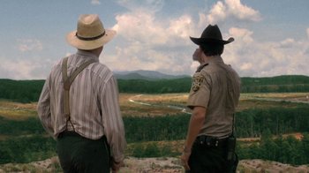 Movie still from “The Walking Dead” (2010), directed by Daniel Sackheim – A couple of men standing on top of a hill; Wide shot, High angle