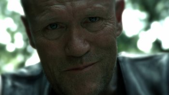 Movie still from “The Walking Dead” (2010), directed by Daniel Sackheim – A man's face in a black shirt; Close Up shot, Low angle
