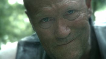 Movie still from “The Walking Dead” (2010), directed by Daniel Sackheim – An old man with a shaved head and blue eyes looking at the camera; Extreme Close Up shot, Over the shoulder angle