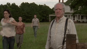 Movie still from “The Walking Dead” (2010), directed by Daniel Sackheim – Two men and a woman standing in a field; Medium shot, Low angle