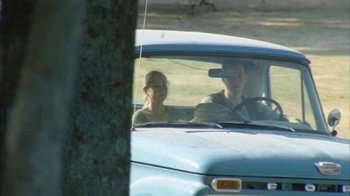 A man and a woman in a blue truck