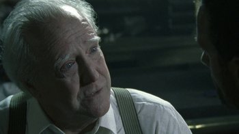 Movie still from “The Walking Dead” (2010), directed by Daniel Sackheim – An old man with a white shirt and suspenders looks to his left; Close Up shot, Over the shoulder angle