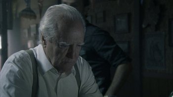 Movie still from “The Walking Dead” (2010), directed by Daniel Sackheim – An older man sitting in front of a computer screen; Close Up shot, Over the shoulder angle