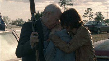 Movie still from “The Walking Dead” (2010), directed by Daniel Sackheim – An older man holding a baby and a rifle; Medium shot, Over the shoulder angle