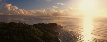 Movie still from “The Wandering Earth” (2019), directed by Frant Gwo – The sun is setting over the ocean with a view of the land; Extreme Wide shot, High angle