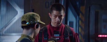 Movie still from “The Wandering Earth” (2019), directed by Frant Gwo – A man in a red shirt is looking at another man in a yellow hat; Close Up shot, Over the shoulder angle