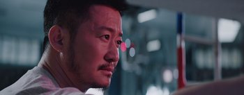 Movie still from “The Wandering Earth” (2019), directed by Frant Gwo – A man's face with a blurry background; Close Up shot, Low angle