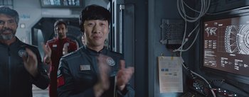 Movie still from “The Wandering Earth” (2019), directed by Frant Gwo – A man wearing a uniform clapping his hands in a room; Close Up shot, Over the shoulder angle