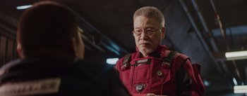 Movie still from “The Wandering Earth” (2019), directed by Frant Gwo – An older man in a red jacket looking at the camera; Close Up shot, Over the shoulder angle