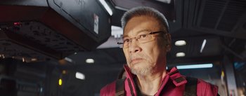 Movie still from “The Wandering Earth” (2019), directed by Frant Gwo – An older man with a beard wearing glasses and a pink jacket; Close Up shot, Low angle