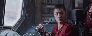 Movie still from “The Wandering Earth” (2019), directed by Frant Gwo – A man holding a pair of scissors while sitting down; Close Up shot, Low angle