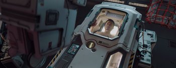 Movie still from “The Wandering Earth” (2019), directed by Frant Gwo – A man is seen through a window of a space ship; Medium shot, Overhead angle