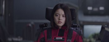 Movie still from “The Wandering Earth” (2019), directed by Frant Gwo – A woman in a red jacket sitting in a chair; Close Up shot, Low angle