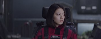 Movie still from “The Wandering Earth” (2019), directed by Frant Gwo – A woman in a red jacket sitting in a chair; Close Up shot, Low angle