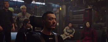 Movie still from “The Wandering Earth” (2019), directed by Frant Gwo – A man sitting in a chair in front of another man; Medium shot, Low angle