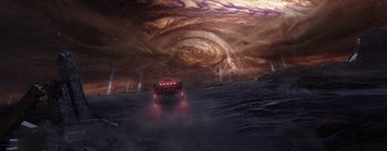 Movie still from “The Wandering Earth” (2019), directed by Frant Gwo – A truck driving down a dirt road under a sky filled with clouds; Extreme Wide shot, High angle