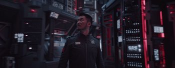 Movie still from “The Wandering Earth” (2019), directed by Frant Gwo – A man wearing a uniform standing next to a wall; Medium shot, Over the shoulder angle