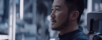Movie still from “The Wandering Earth” (2019), directed by Frant Gwo – A person with a beard looking to his left; Close Up shot, Over the shoulder angle