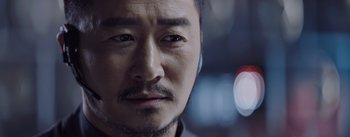Movie still from “The Wandering Earth” (2019), directed by Frant Gwo – A man's face with a blurry background; Close Up shot, Over the shoulder angle