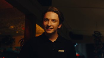 A man in a black shirt smiling for the camera