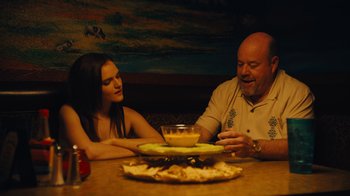 A man and a woman sitting in front of a plate of food