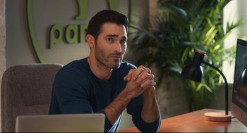Movie still from “Can You Keep a Secret?” (2019), directed by Elise Durán – A man sitting in front of a computer at a table; Medium shot, Over the shoulder angle