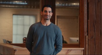 Movie still from “Can You Keep a Secret?” (2019), directed by Elise Durán – A man standing in front of a counter with his hands in his pockets; Medium shot, Over the shoulder angle