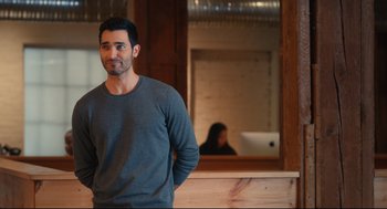 Movie still from “Can You Keep a Secret?” (2019), directed by Elise Durán – A man standing in front of a mirror in a room; Medium shot, Over the shoulder angle