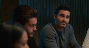 Movie still from “Can You Keep a Secret?” (2019), directed by Elise Durán – A man sitting next to another man in a room; Close Up shot, Over the shoulder angle