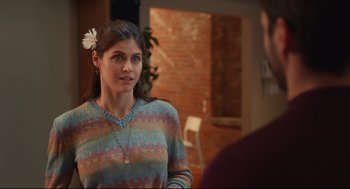 Movie still from “Can You Keep a Secret?” (2019), directed by Elise Durán – A woman in a colorful sweater talking to a man in a brick room; Close Up shot, Over the shoulder angle