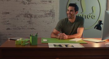 Movie still from “Can You Keep a Secret?” (2019), directed by Elise Durán – A man sitting at a table with a green table cloth; Medium shot, Over the shoulder angle
