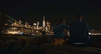 Movie still from “Can You Keep a Secret?” (2019), directed by Elise Durán – Two people are sitting on a bench looking at the city lights; Wide shot, Over the shoulder angle