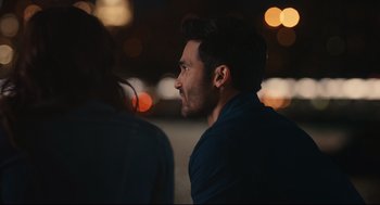 Movie still from “Can You Keep a Secret?” (2019), directed by Elise Durán – A person sitting in front of some lights; Close Up shot, Over the shoulder angle