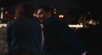 Movie still from “Can You Keep a Secret?” (2019), directed by Elise Durán – A man and a woman standing next to each other in the dark; Medium shot, Over the shoulder angle