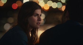 Movie still from “Can You Keep a Secret?” (2019), directed by Elise Durán – A beautiful young woman sitting in front of a bunch of lights; Close Up shot, Over the shoulder angle