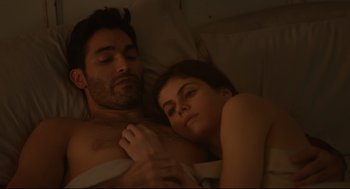 Movie still from “Can You Keep a Secret?” (2019), directed by Elise Durán – A man and a woman laying in bed together; Medium shot, Overhead angle