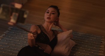 Movie still from “Can You Keep a Secret?” (2019), directed by Elise Durán – A beautiful young lady sitting on the ground; Medium shot, High angle