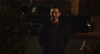 Movie still from “Can You Keep a Secret?” (2019), directed by Elise Durán – A man standing in front of a car at night; Medium shot, Over the shoulder angle