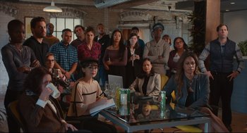 Movie still from “Can You Keep a Secret?” (2019), directed by Elise Durán – A group of people gathered around a glass table; Wide shot, High angle
