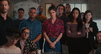 Movie still from “Can You Keep a Secret?” (2019), directed by Elise Durán – A group of people standing around a table; Medium shot, Low angle