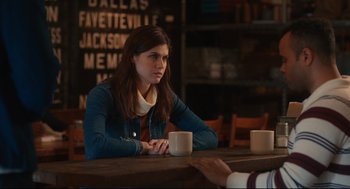 Movie still from “Can You Keep a Secret?” (2019), directed by Elise Durán – A woman sitting at a table with a cup of coffee; Medium shot, Over the shoulder angle