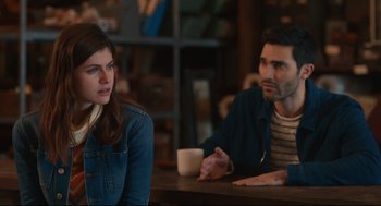 Movie still from “Can You Keep a Secret?” (2019), directed by Elise Durán – A man and a woman sitting at a wooden table; Medium shot, Over the shoulder angle