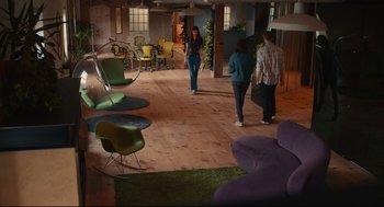 Movie still from “Can You Keep a Secret?” (2019), directed by Elise Durán – A group of people standing in a room with chairs; Extreme Wide shot, High angle
