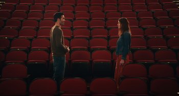 Movie still from “Can You Keep a Secret?” (2019), directed by Elise Durán – A man and a woman are standing in a movie theater; Wide shot, High angle