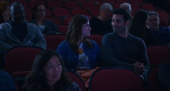 Movie still from “Can You Keep a Secret?” (2019), directed by Elise Durán – A man and a woman are sitting in a movie theater; Medium shot, Over the shoulder angle
